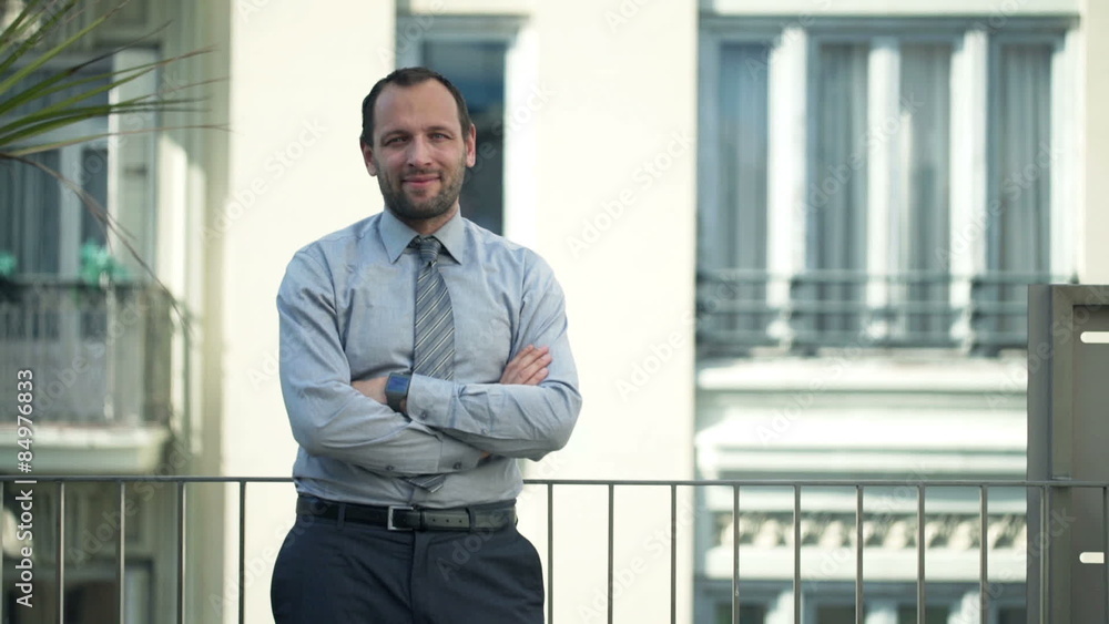 Portrait of smiling, handsome businessman standing on balcony
Portrait of smiling, handsome businessman standing on balcony
