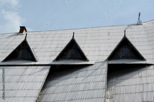 Steep roof covered with silver corrugated plates.