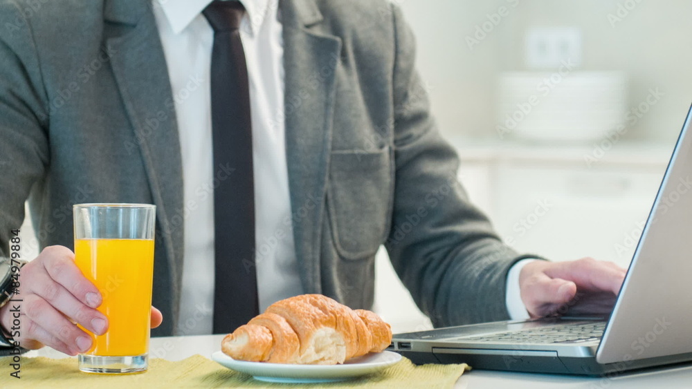 Vertical dolly shot of businessman drinking juice and working on Vertical dolly shot of businessman drinking juice and working on