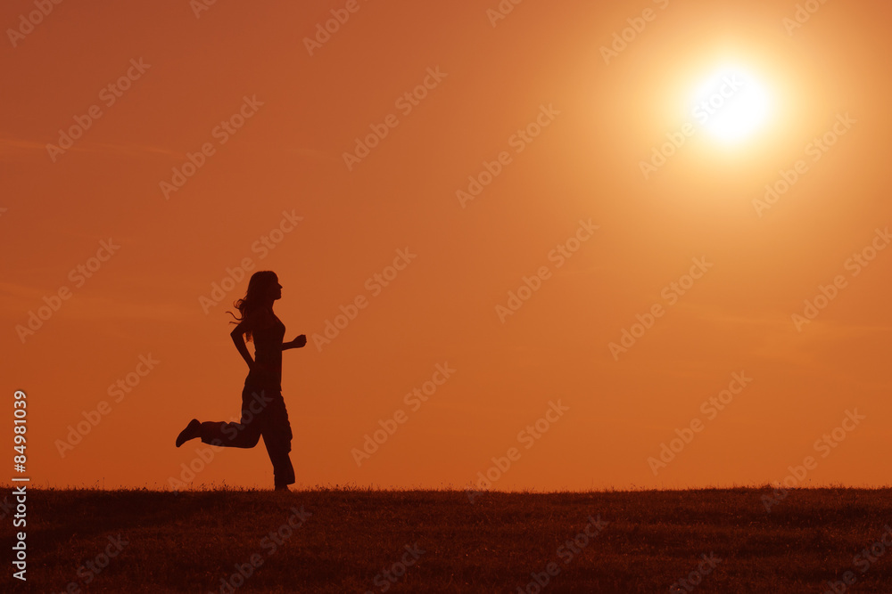 Silhouette of girl jogging in the sunset