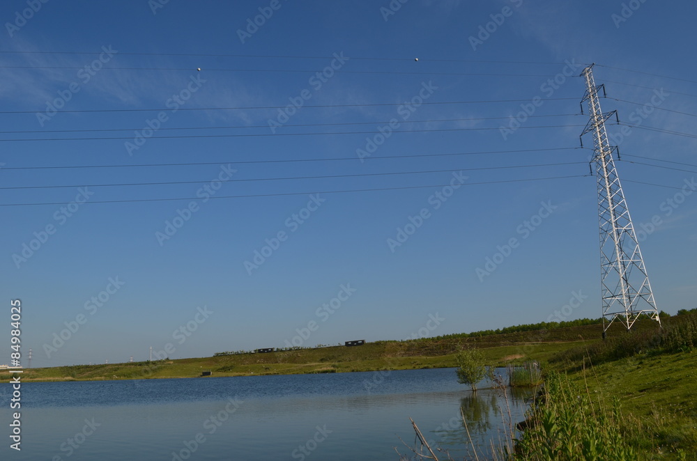 Electricity pole and lake in Antwerp polder