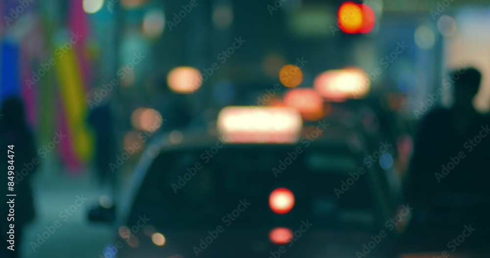 Blurred background of city street at night with passenger entering taxi cab Blurred background of city street at night with passenger entering taxi cab