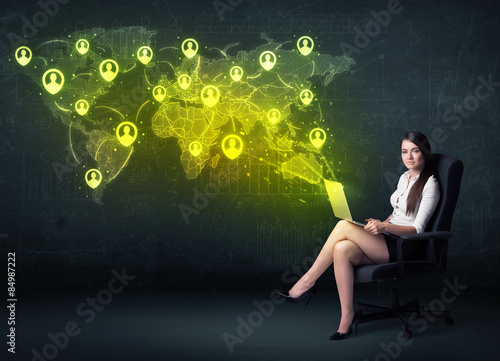 Businesswoman in office with laptop and social network world map