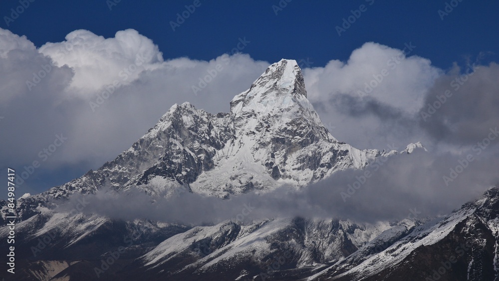 Naklejka premium Peak of Ama Dablam surrounded by clouds