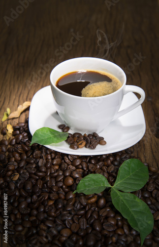 Cup of coffee with smoke on old wooden background