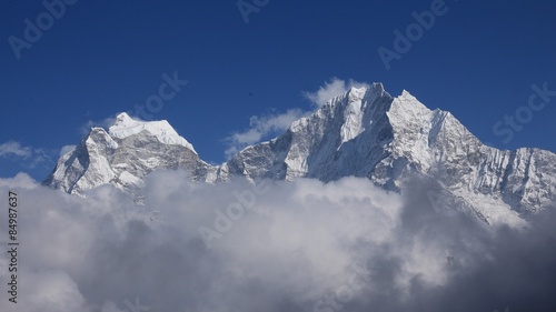 High mountains Thamseku and Kangtega surrounded by clouds, scene on the way to Everest Base Camp photo