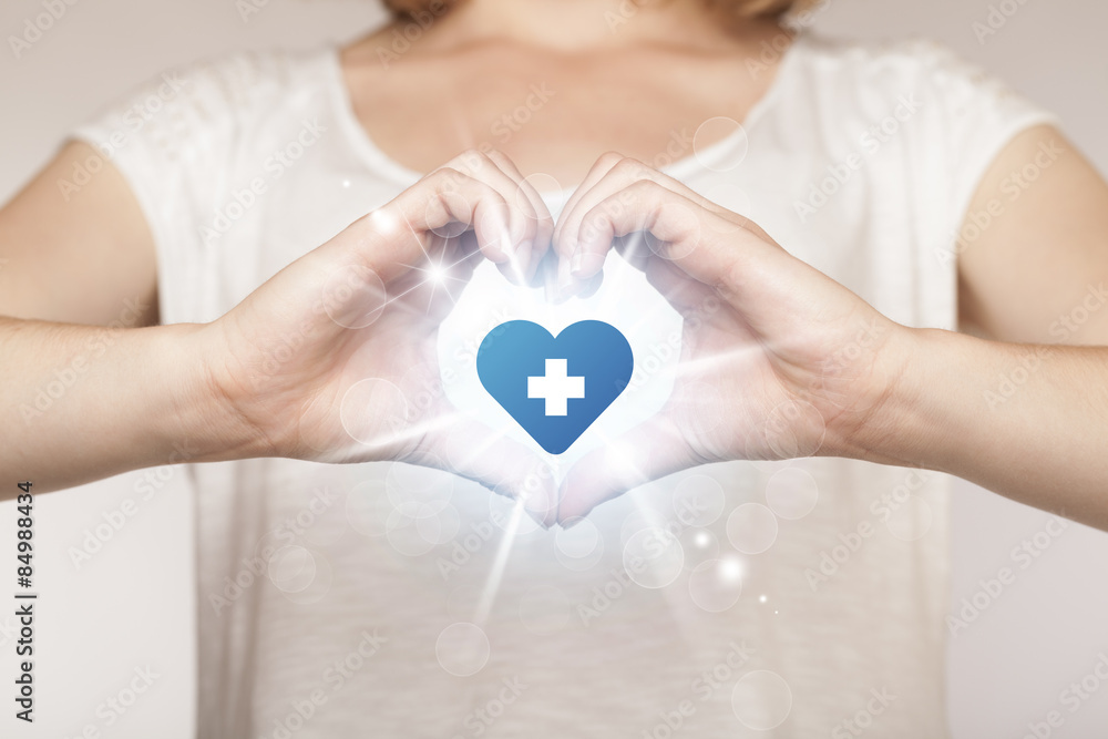 Hands creating a form with heart blue cross Hands creating a form with heart blue cross