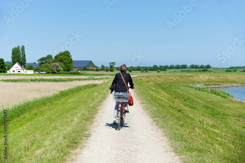 Frau auf Fahrrad am Deich © grafikplusfoto