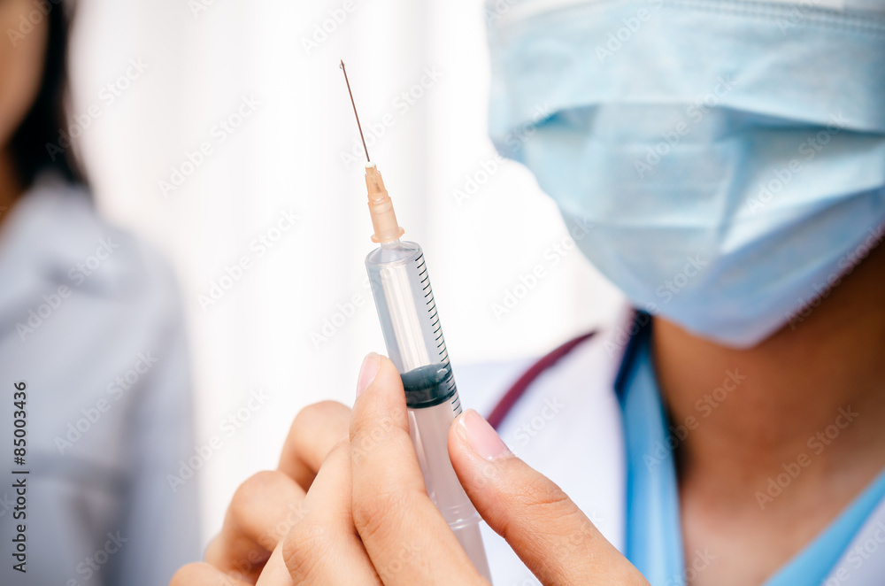 doctor holding syringe for injecting the patient
doctor holding syringe for injecting the patient