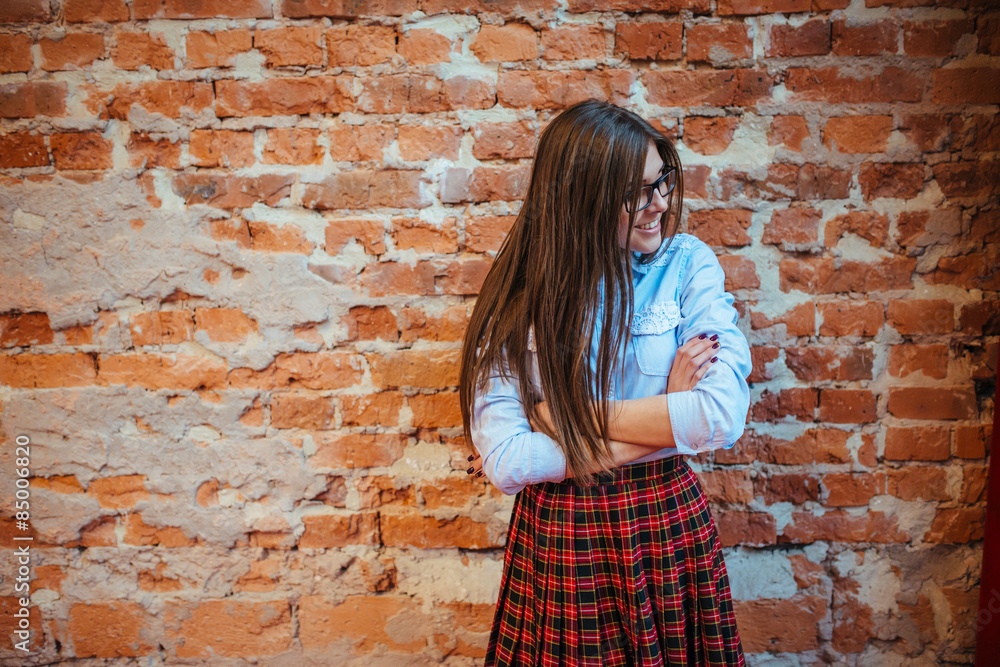 Beautiful young woman stands near the old brick wall. Youth styl Beautiful young woman stands near the old brick wall. Youth styl
