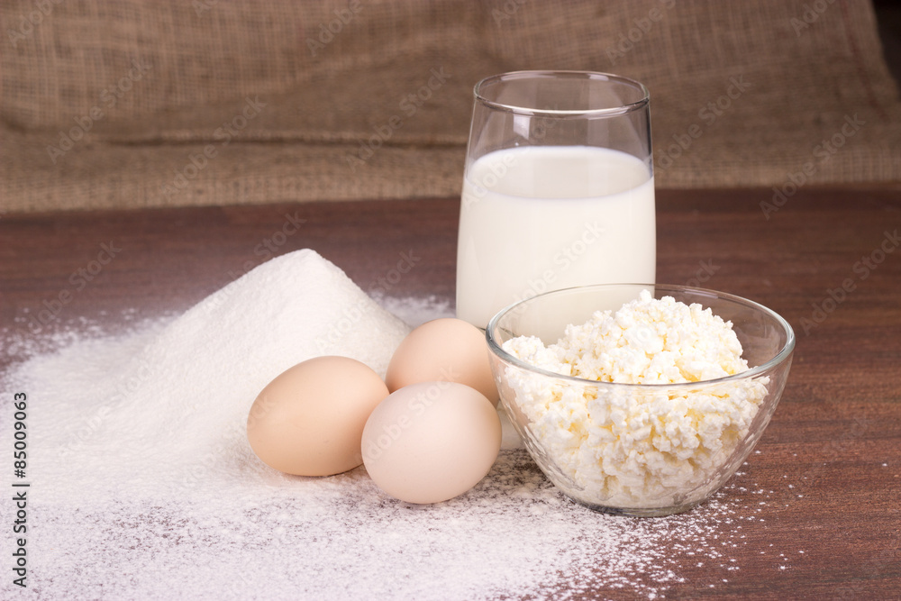 glass cup with milk, a glass bowl with cottage cheese, eggs, flo glass cup with milk, a glass bowl with cottage cheese, eggs, flo