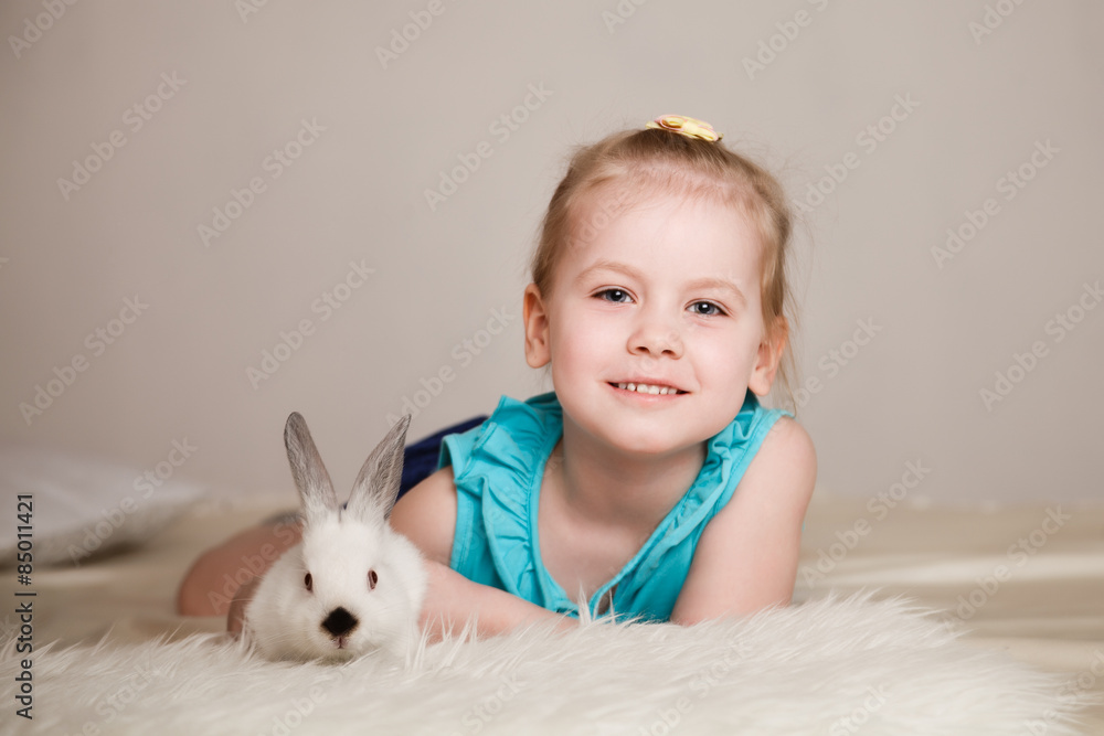 Cute little girl playing with white rabbits Cute little girl playing with white rabbits