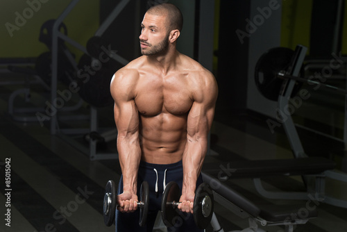 Bodybuilder Exercising Biceps With Dumbbells