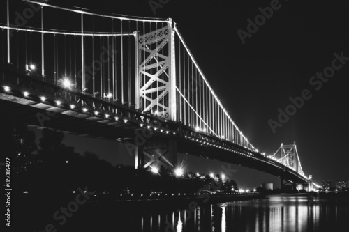Black and white photo of the Benjamin Franklin Bridge at night, © jonbilous