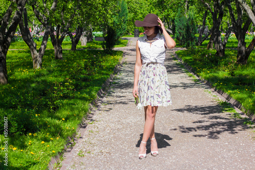 Attractive woman with a hat is walking in the Park on a sunny day © Alisa Bezukladnikova