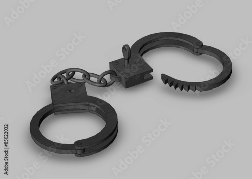 Iron handcuffs opened with a key close-up on a grey background