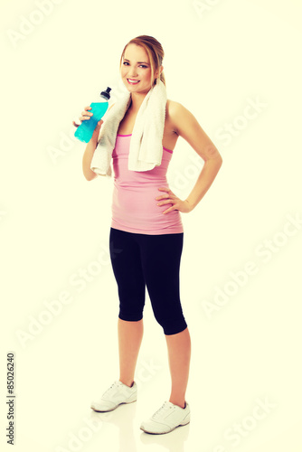 Woman in fitness clothes drinking isotonic drink. © Piotr Marcinski