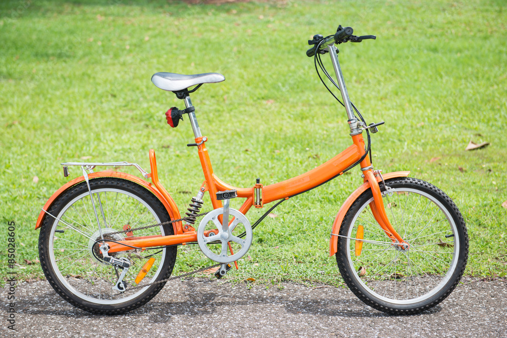 orange folding bicycles in park