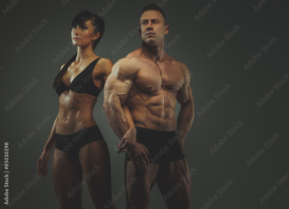 Fototapeta premium Woman and man bodybuilders posing in studio