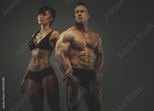 Woman and man bodybuilders posing in studio