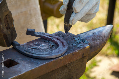 blacksmith forges a horseshoe