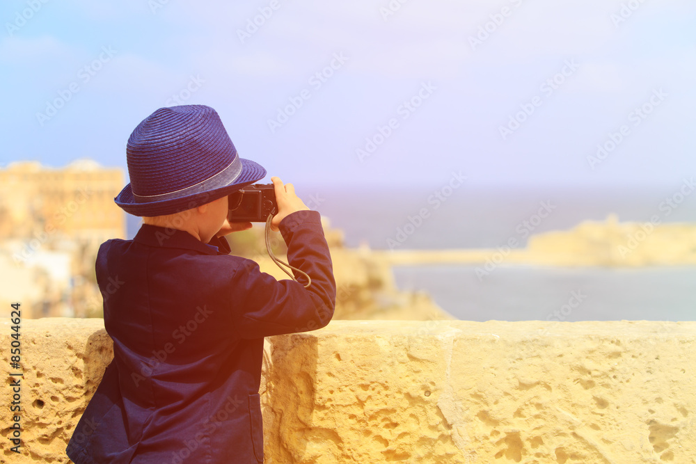 smart little boy taking photos while travel in Europe
