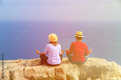 young couple practicing yoga in scenic mountains