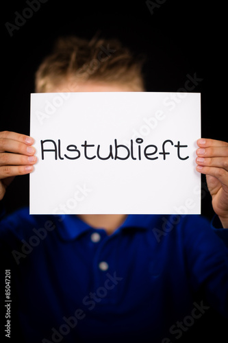 Child holding sign with Dutch word Alstublieft - Please