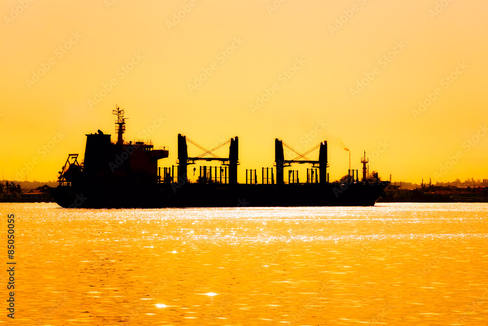 Silhouette of a commercial ship at sunset