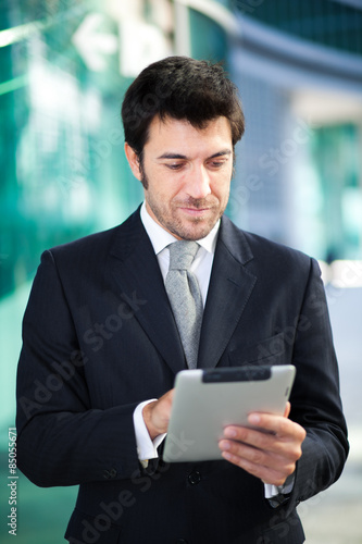 Confident businessman using his tablet