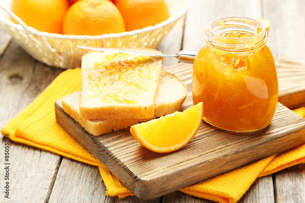 Bread and orange jam on grey wooden background