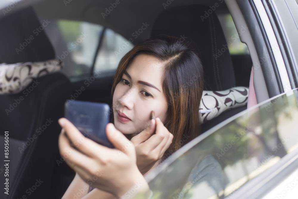 woman in doing make up in car