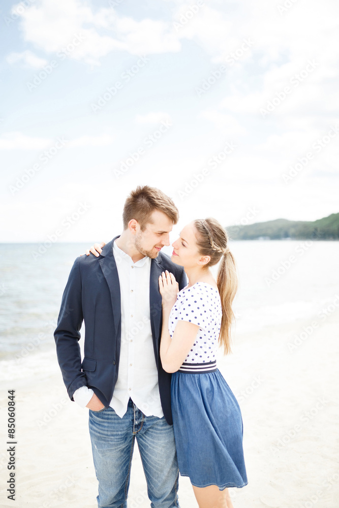 European couple relaxing on the sea beach hugging each other and talking European couple relaxing on the sea beach hugging each other and talking