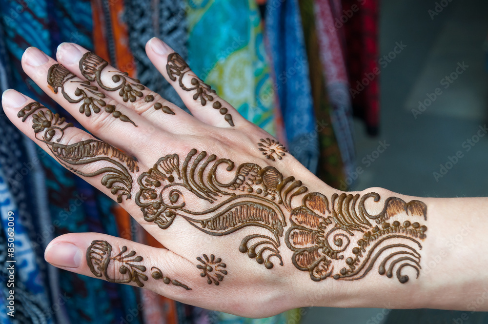 Painting Henna paste on woman's hand