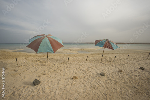 Umbrellas on a tropical beach with stormy sky © Paul Vinten