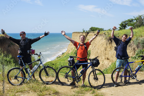 young caucasian byciclists cheering on the seaside