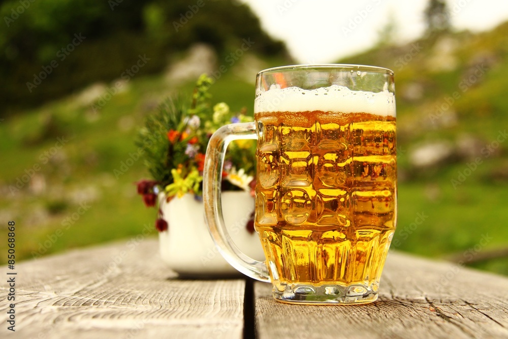 halbe bier mit blumen auf alm II Stock-Foto | Adobe Stock