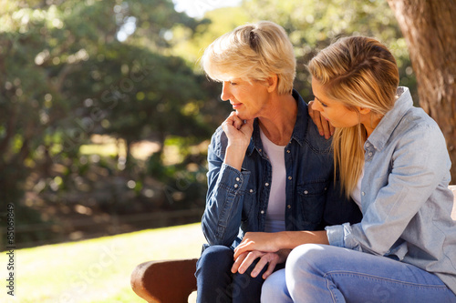 young daughter comforting senior mother photo