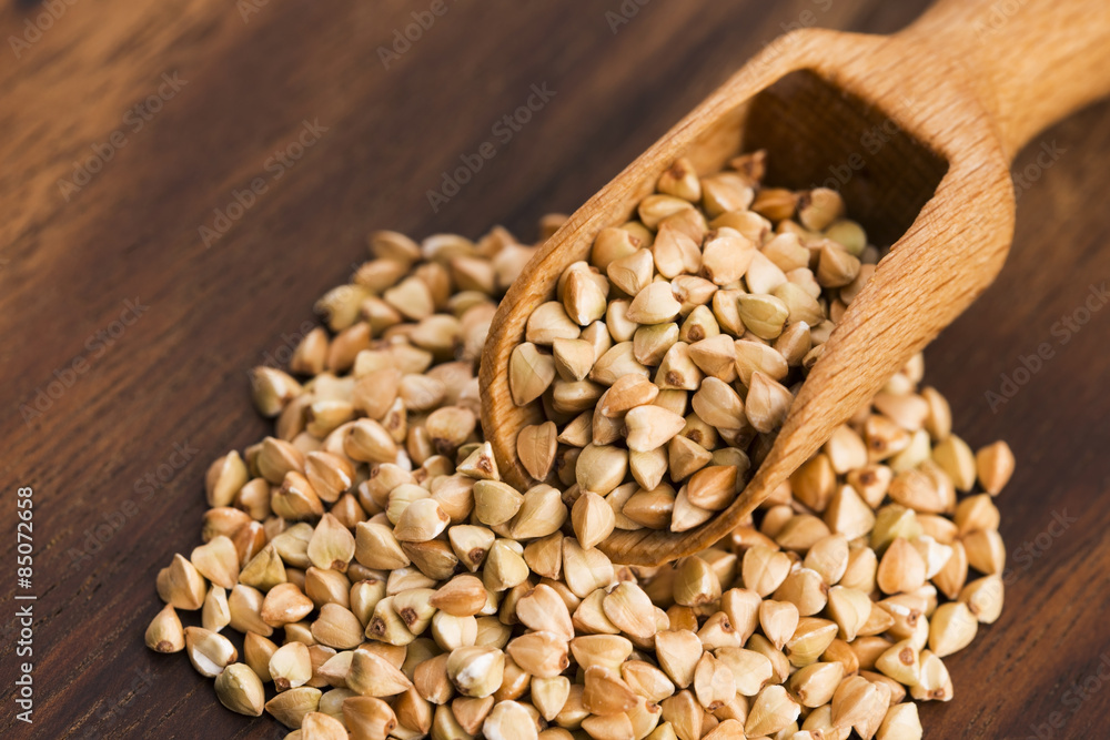 Buckwheat with a spoon on a wooden boards background Buckwheat with a spoon on a wooden boards background