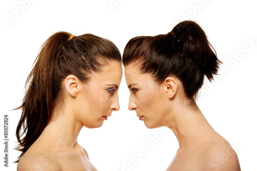 Two sisters standing face to face.