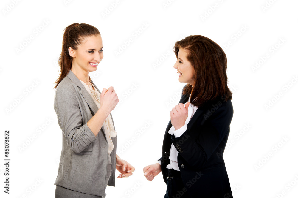 Happy two businesswomen making fists. Happy two businesswomen making fists.