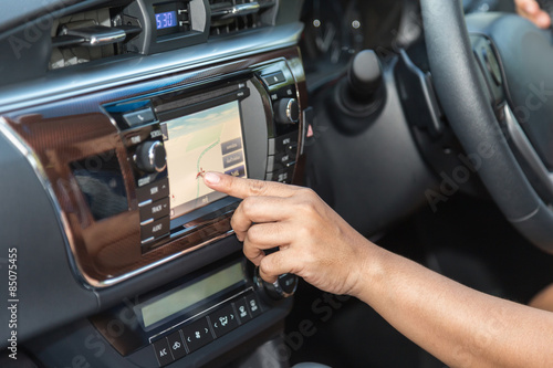 Driver hand press navigation screen in the car © SKT Studio
