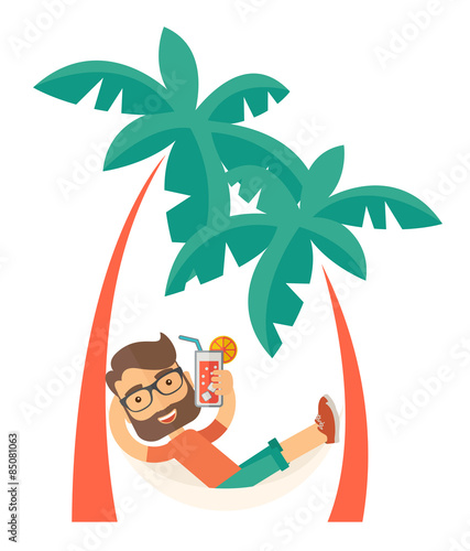Young man on th beach relaxing and drinking cocktail.