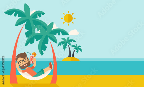 Young man on th beach relaxing and drinking cocktail.
