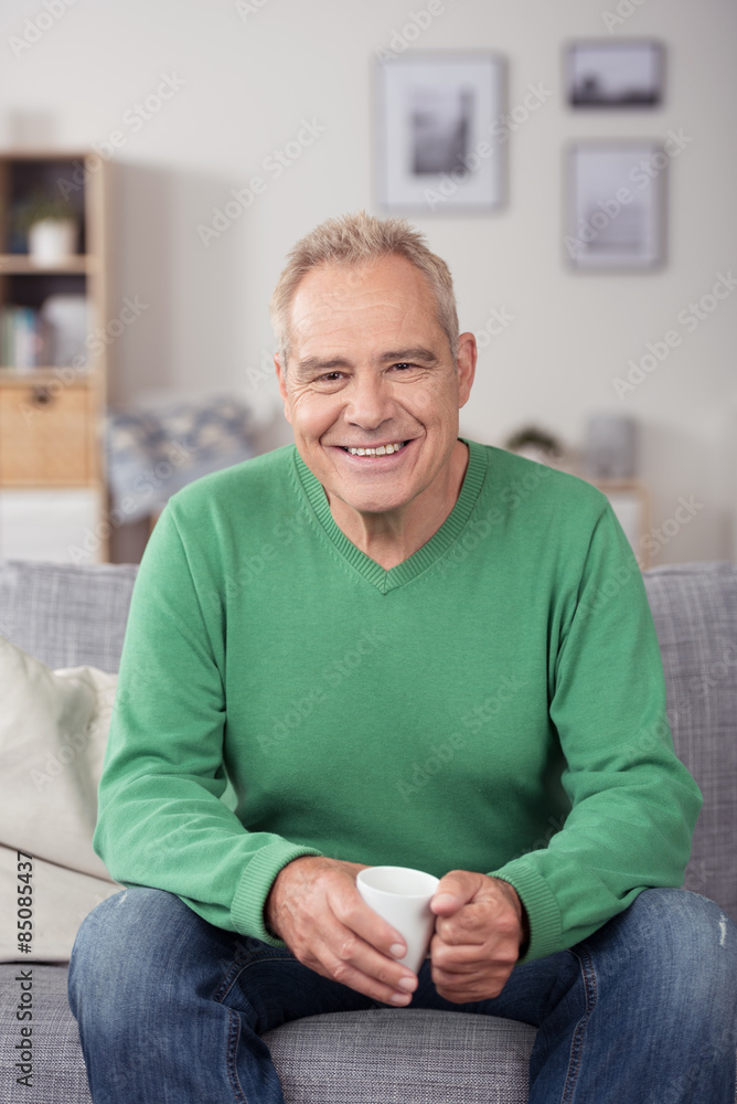 senior sitzt entspannt auf dem sofa in seiner wohnung senior sitzt entspannt auf dem sofa in seiner wohnung