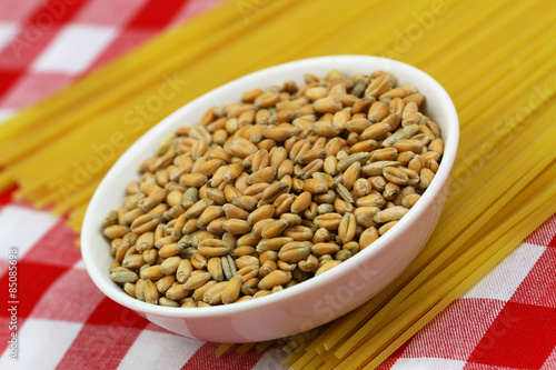 Wheat in bowl on uncooked spaghetti  