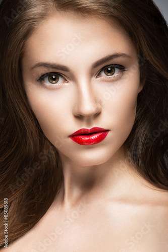 Beautiful woman with evening make-up, red lips and curls. Beauty face.