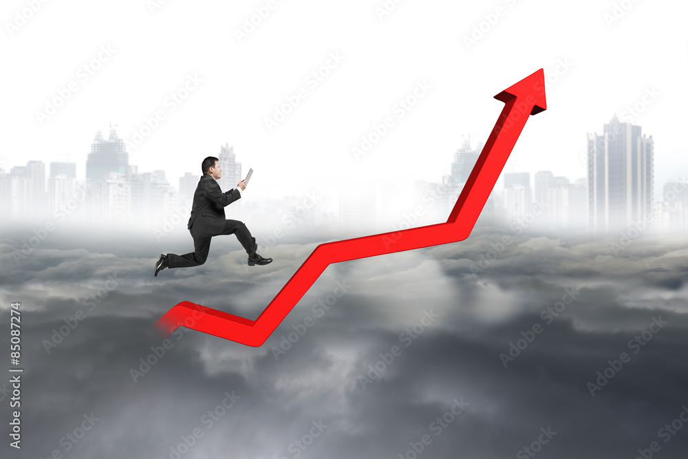 Business man holding tablet jumping on red growth trend line Business man holding tablet jumping on red growth trend line