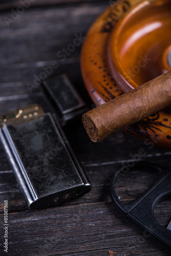 Fototapeta Naklejka Na Ścianę i Meble -  Cuban cigar in ashtray with lighter and cutter