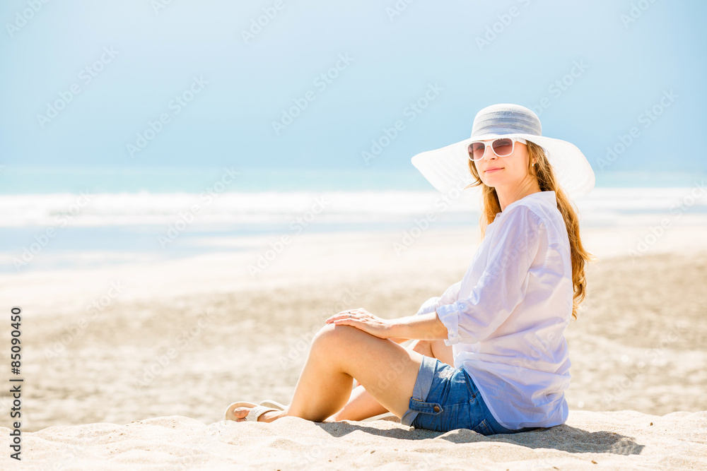 Beautifil young woman sitting on the beach at sunny day enjoing Beautifil young woman sitting on the beach at sunny day enjoing